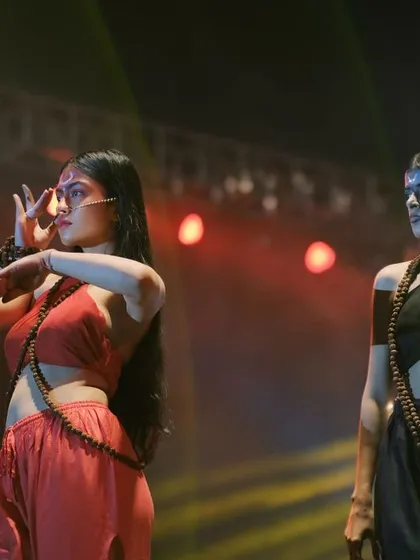 A creative dance performance during a college fashion show. This shot captures the fusion of traditional dance mudras with modern theatrical presentation.