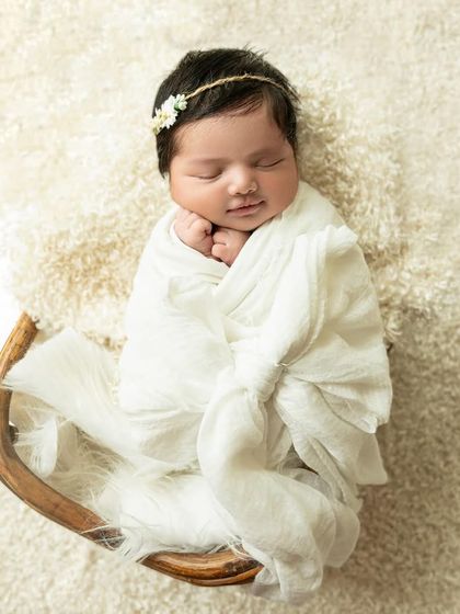 For the sweetest of smiles. A simple white swaddle and a delicate floral headband are perfect for capturing those fleeting, dreamy smiles.