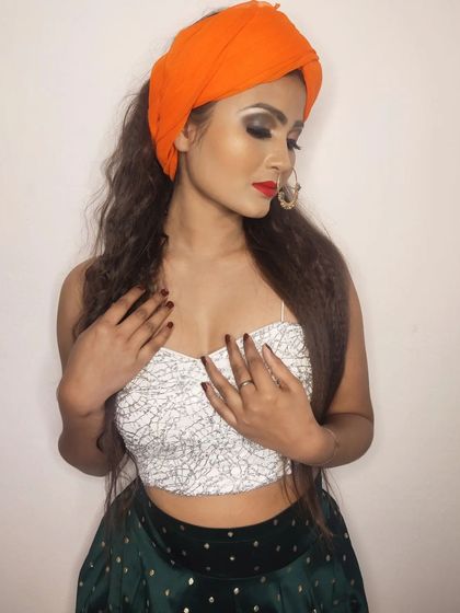 A studio-style shot showcasing the makeup details for the Republic Day theme. The look features dark, smokey eyeshadow, a classic red lip, and crimped hair for added texture.