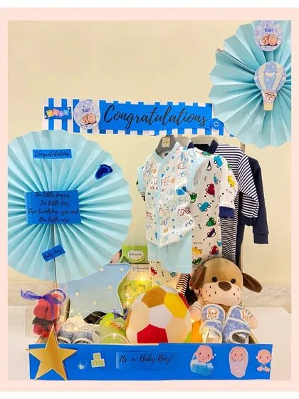 Another one of our custom baby closet hampers, this time for a boy. It features a curated selection of clothes, a soft soccer ball, and a cuddly puppy toy.