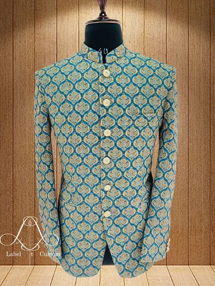 This Bandhgala jacket is crafted from a beautiful teal fabric with a golden brocade pattern. It’s a classic design that I've updated with a slim, modern fit. This piece is perfect for making a sophisticated statement at any formal event.