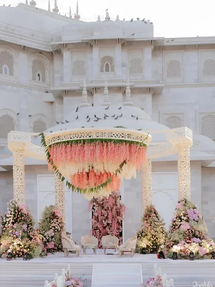 An absolutely dreamy mandap we designed at Fairmont Jaipur, featuring a canopy of cascading pink and white wisteria against the palace's white architecture. This is royal wedding decor at its finest.