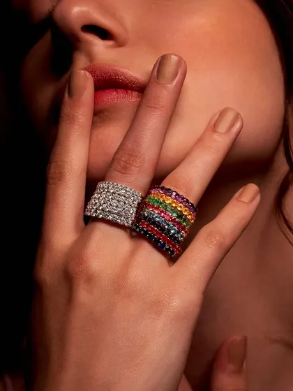 Bold statements for a confident style. Here, a hand wears two of my wide band rings: one fully encrusted with brilliant diamonds, the other a rainbow of vibrant gemstones. These pieces are for those who are not afraid to shine.