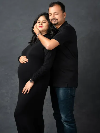 A tender moment of connection. The husband's gentle touch and the couple's soft expressions make this a deeply emotional portrait.