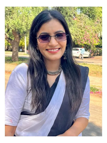 A portrait in a classic black and white saree. This traditional attire is also a powerful professional statement for a woman in law.