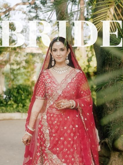 A classic bridal portrait with the bride looking directly at the camera, framed by lush greenery. The "BRIDE" text overlay makes a bold statement.