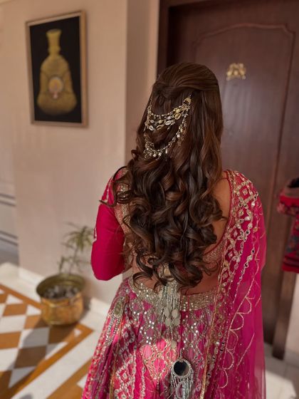 A side view of the half-up style with a traditional accessory, perfect for a bridal look.