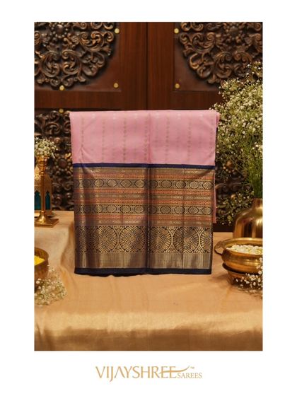A stunning pink Kanjivaram with a blue border and intricate gold zari weaving, the epitome of grace.