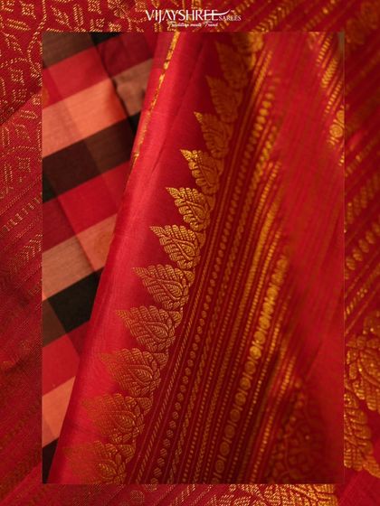 A close-up of the checked Kanjivaram's border, showing the intricate leaf motifs woven in gold zari.
