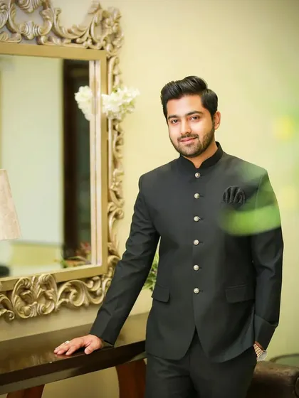 Posed by a mirror, this groom looks sharp and sophisticated. The makeup is subtle, providing a clean, matte finish that's perfect for photography.