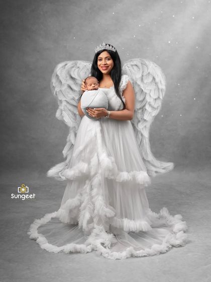 A mother's love makes her an angel on earth. This creative portrait with angel wings symbolizes the protective and divine love a mother has for her child.