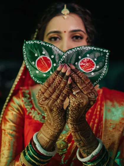 The traditions of a Bengali wedding are so visually rich and meaningful. Here, the bride performs the Shubho Drishti ritual, hiding her face behind betel leaves. I capture these key cultural moments with an artistic focus on details like the intricate mehndi and the emotion in her eyes.