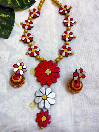 A duplicate image of the classic red and white floral necklace, showing the full three-layer pendant and matching earrings.