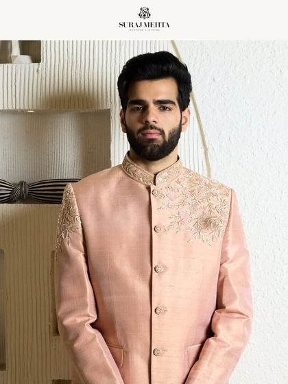 A closer look at the baby pink bandhgala jacket. The refined threadwork adds a touch of warmth and sophistication, making it ideal for festive gatherings.