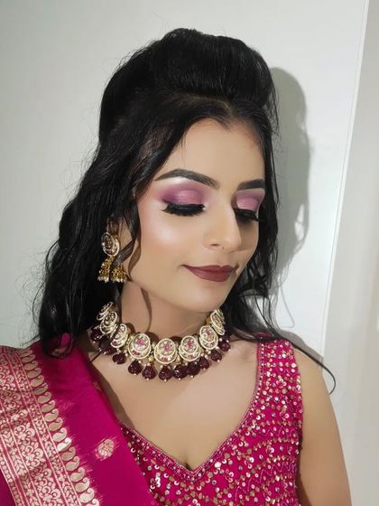 The eyeshadow is blended perfectly for a dramatic effect, complemented by a strong highlight on the cheekbones.