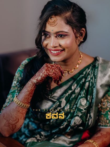 A beautiful portrait of a bride in a green saree, capturing her bright smile and traditional look.