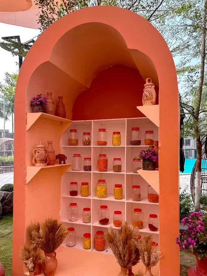 An arched nook filled with jars of colorful spices, creating a beautiful and aromatic display that enhances the multi-sensory experience of the event.