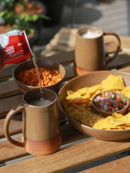A student's barware collection, 'Moments Together,' inspired by cherishing gatherings with loved ones. This image shows beer mugs and snacks, creating a warm, inviting scene.