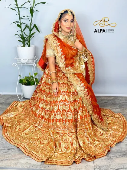 The complete bridal look, seated to display the stunning spread of the embroidered lehenga. The makeup is set to be radiant even from a distance.