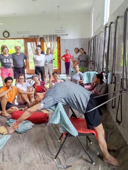 Students watch intently as I demonstrate a back-opening pose using the wall ropes. This is a common sight during our intensive workshops.