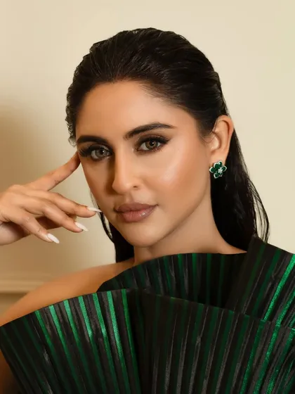 This angle highlights the smooth, airbrushed quality of the skin finish and the clean lines of the eye makeup. The wet-look hair is pulled back to keep the focus entirely on her face and the statement dress.