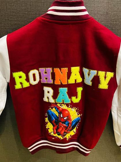A super cool Spider-Man varsity jacket. The combination of the maroon jacket, white sleeves, and colorful patches makes for a heroic look.