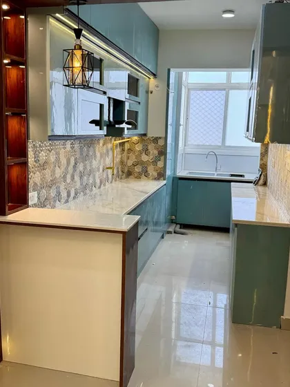 A full view of the teal modular kitchen, showing how the layout maximizes space and functionality in a galley-style setup.