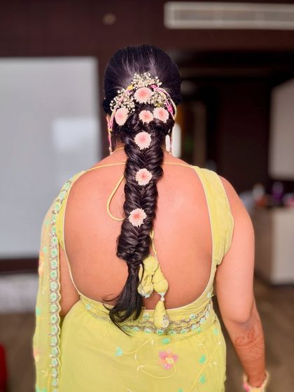 A close-up of the beautiful floral fishtail braid I created for this Haldi ceremony. It's a perfect hairstyle for keeping the hair off the face while looking festive.