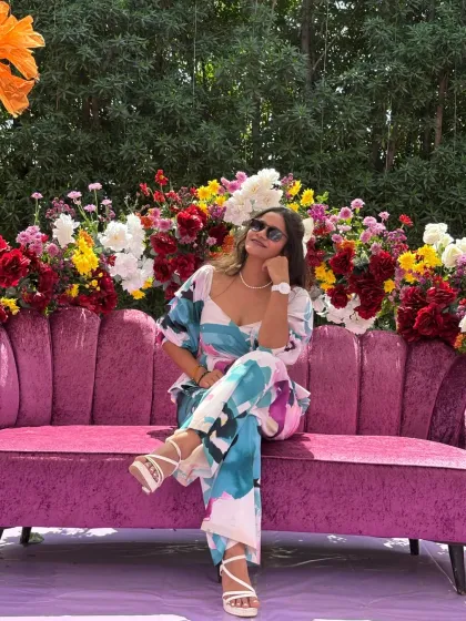 Taking a moment to relax on the plush pink sofa at the carnival-themed wedding event.