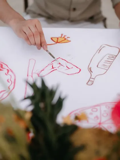 A guest participates in the interactive table overlay, painting a detail from the couple's story.