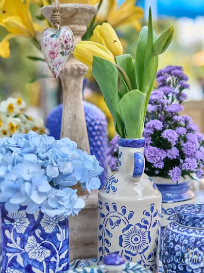 Another detail shot of the vibrant centerpiece, with a small, heart-shaped floral ornament hanging from a candle stand.