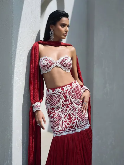 A pearl-embroidered lehenga in a crimson hue, featuring a sculpted bralette and a crushed dupatta. This look is a whole mood, blending tradition with a contemporary edge.