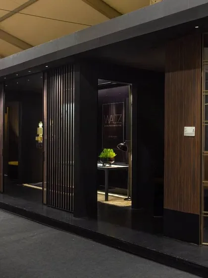 This side view of the JB Glass exhibition stall shows how the linear layout becomes an advantage. The design invites passersby to view a series of curated vignettes through different openings, turning the entire booth into an engaging and visually compelling experience.