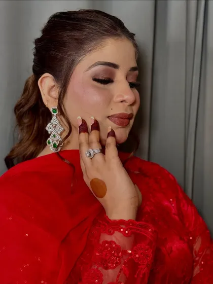 A close-up of this soft glam look in a red outfit. The focus is on the flawless eye makeup and the perfectly matched nude lipstick.