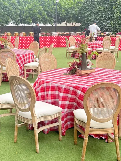 Outdoor seating with red and white checkered tablecloths, continuing the Wonderland theme in a picnic-style setting.