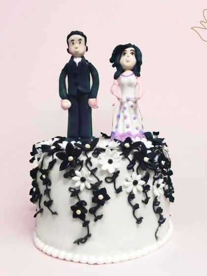 A timeless black and white theme for Parth and Vanshika's anniversary. The elegant cake is crowned with custom fondant toppers, making it a sophisticated and personal tribute to their love story.