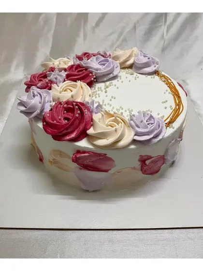 A beautiful cake with a mix of colorful rosettes on top. This design is a great way to add a splash of color to your celebration.