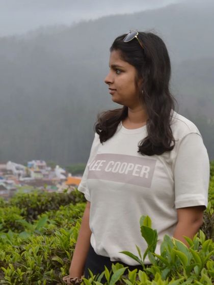 A candid shot of a traveler looking out over the tea estates and the town below.