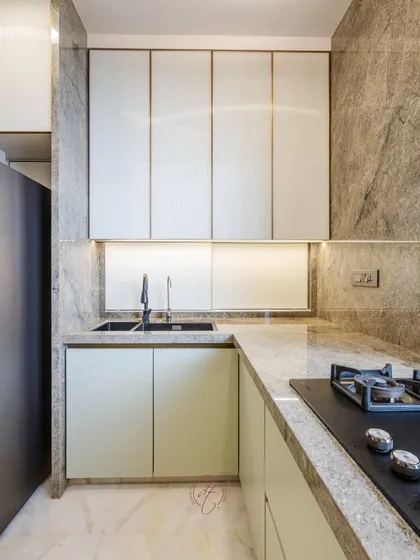 A close-up of the sink and hob area. The seamless look is achieved by using the same exotic Brazilian stone for both the countertop and the backsplash.