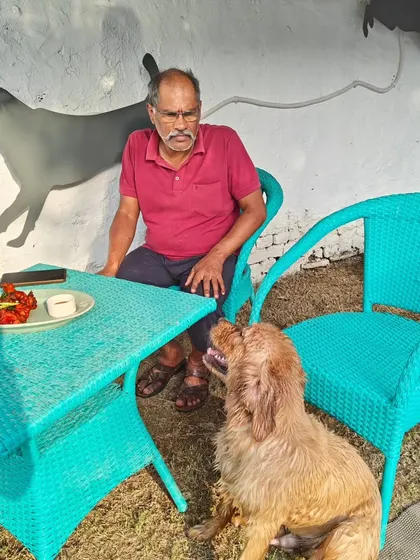 A pet parent enjoying a snack at our cafe while his dog waits patiently for a bite. It's a perfect picture of a day well spent.