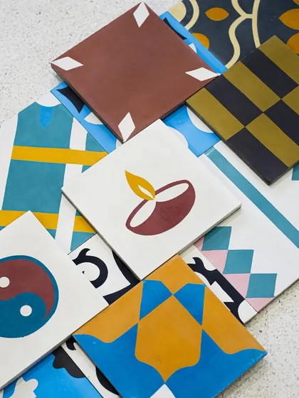 Our fascinating Crimps Collection tiles offer a modern take on traditional cement tiles. This assortment shows various custom patterns and colors, from geometric designs to playful symbols like a diya.