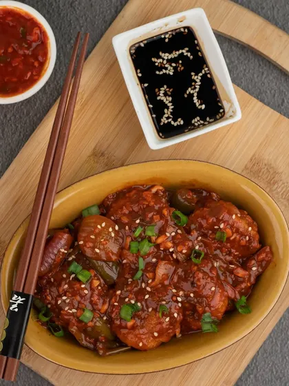 Just trying to make the momo-st of my day. A delicious plate of pan-fried momos in a savory sauce.