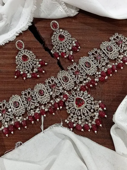 My premium Victorian choker sets are perfect for adding vintage elegance to your bridal or festive look. This particular set features intricate silver work studded with brilliant stones and rich red bead drops.