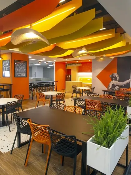 The office canteen at Scientific Games is a vibrant, multi-functional space for dining and socializing. We designed a dramatic ceiling with colorful acoustic baffles and used a mix of seating arrangements to create an energetic atmosphere that encourages employees to connect.