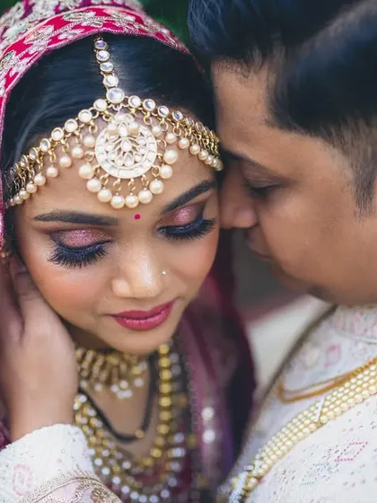A royal reception look for this dainty beauty, featuring dramatic pink and gold eye makeup and a regal matha patti.