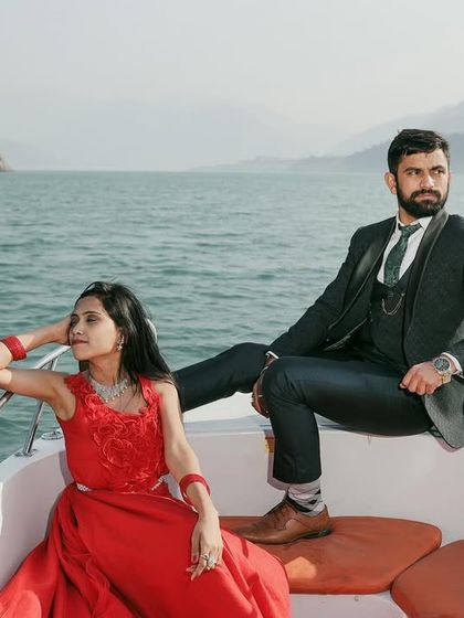 A stylish, magazine-cover-worthy shot of the couple on a speedboat. Their confident poses and the stunning scenery create a powerful and glamorous image.