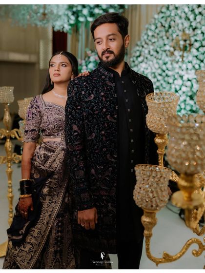 A stylish portrait of the couple at their reception, with ornate candle holders adding to the luxurious ambiance.