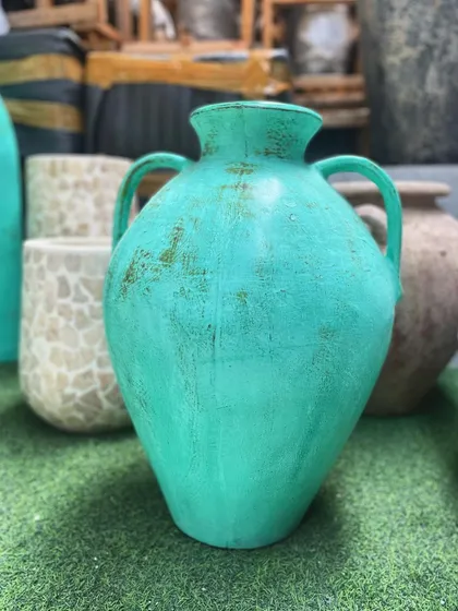A small, two-handled vase in a vibrant distressed teal, perfect for a pop of color on a shelf or table.