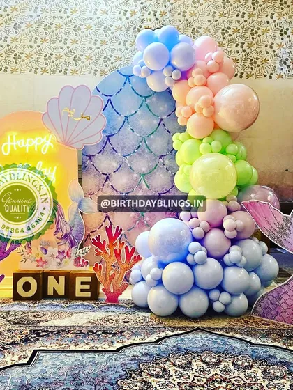 A different angle of the pastel mermaid first birthday, showing the coral and mermaid tail cutouts.