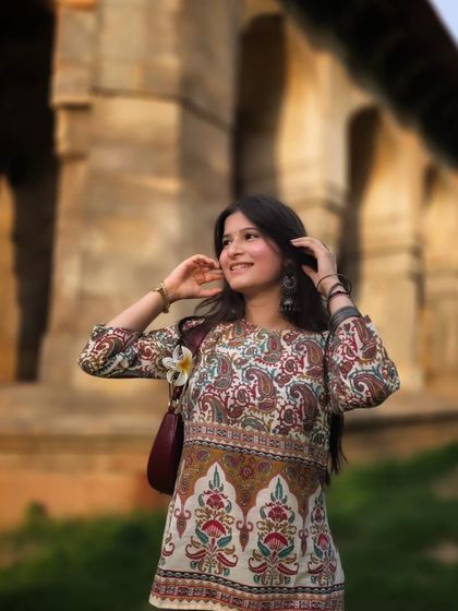 A beautiful candid shot with a soft, blurry background that makes the subject pop. Her happy expression and the flower in her hair add to the cheerful vibe of this portrait.